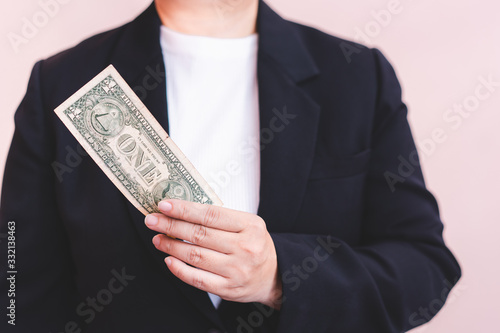 Woman wearing suit hand holding money, one dollar banknotes.