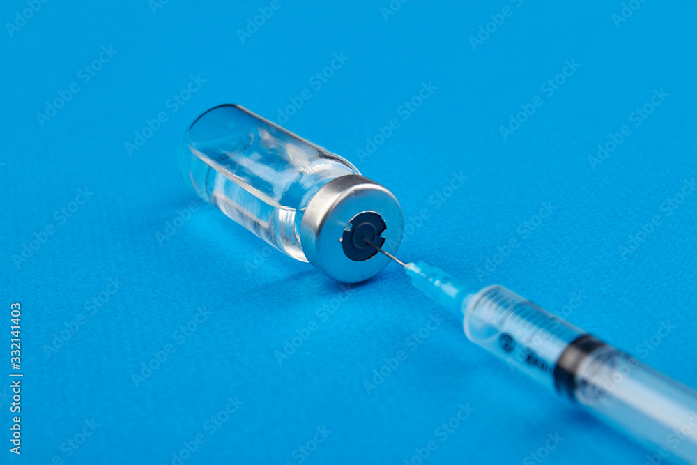 Syringe and medicine for injection. The needle sticks through the vial cap. Syringe and medicine for injection. The needle sticks through the vial cap.