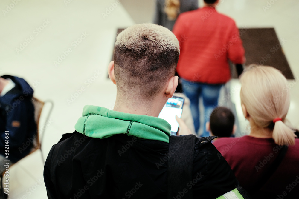 A young man with a smartphone in his hands goes down the escalator. A young man with a smartphone in his hands goes down the escalator.