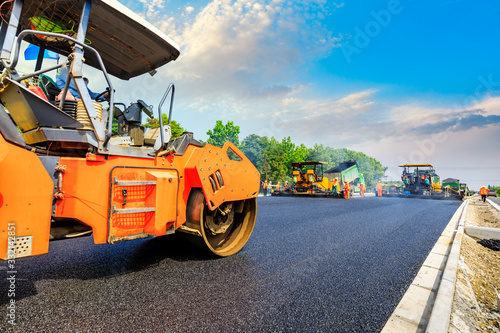 Construction site is laying new asphalt road pavement,road construction workers and road construction machinery scene.highway construction site landscape. © ABCDstock