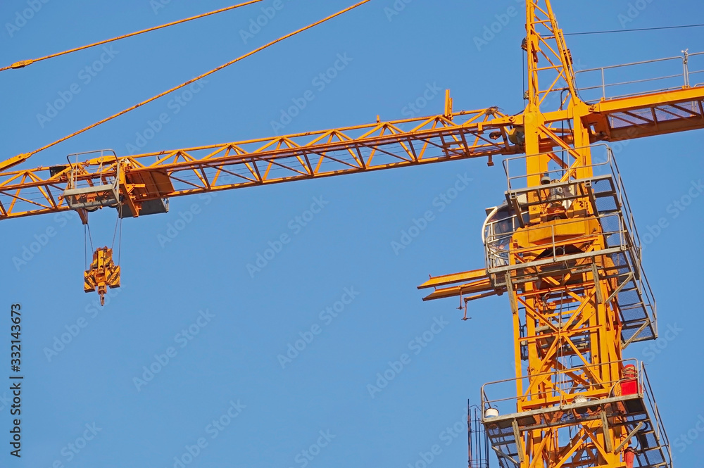 yellow construction crane tower on background sky