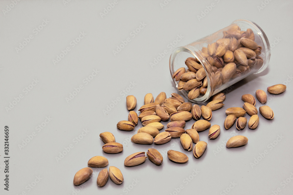 pistachio nuts in glass box on light background. pistachio nuts in glass box on light background.