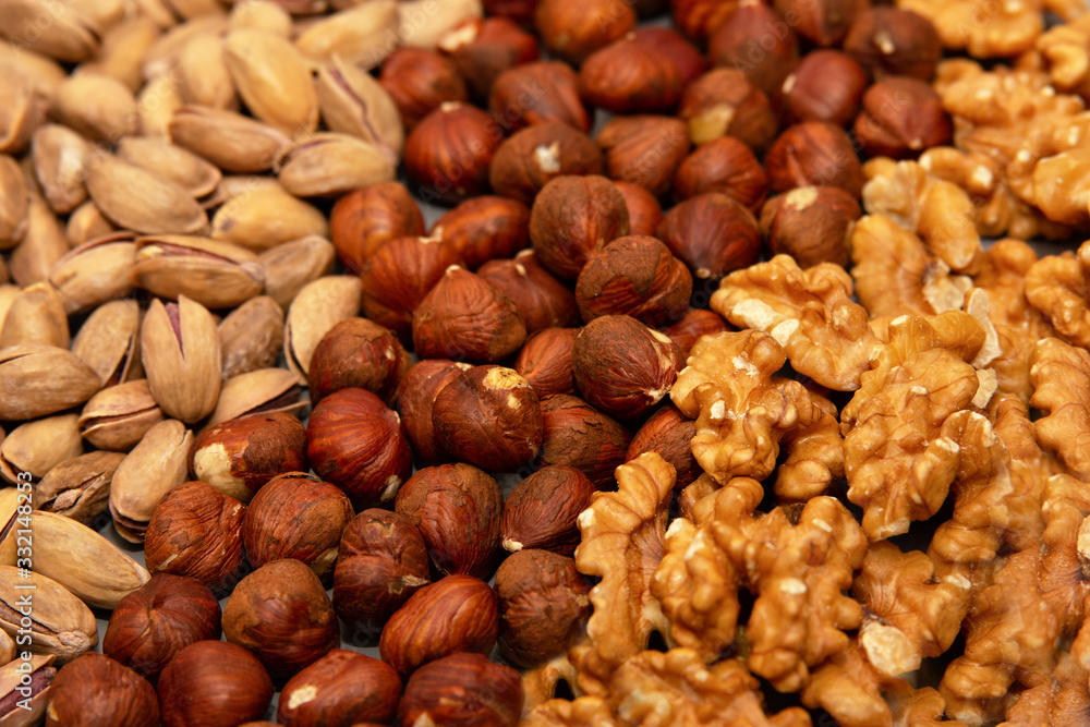 hazelnut, walnut and pistachio nut. mixed assorted nuts in glass box on light background. hazelnut, walnut and pistachio nut. mixed assorted nuts in glass box on light background.