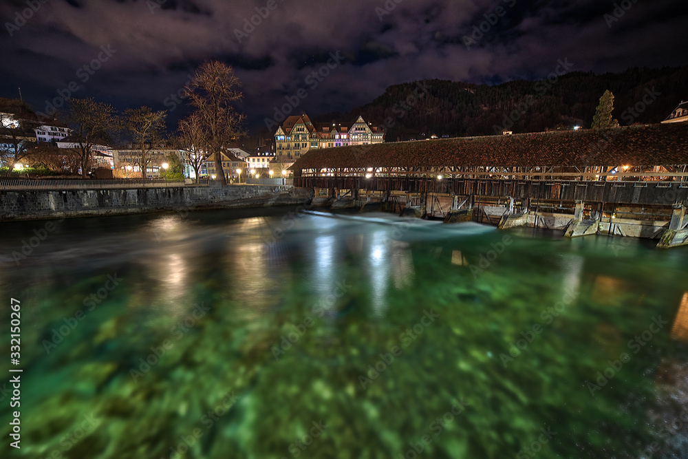 Naklejka premium Flowing water under bridge during overcast night