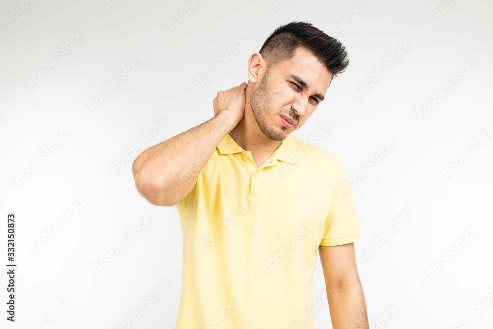 brunette man feels severe pain in his neck on a white studio background brunette man feels severe pain in his neck on a white studio background