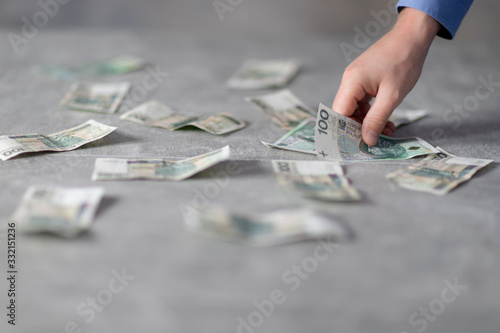Polka gotówka na stole, ręka trzymająca banknot