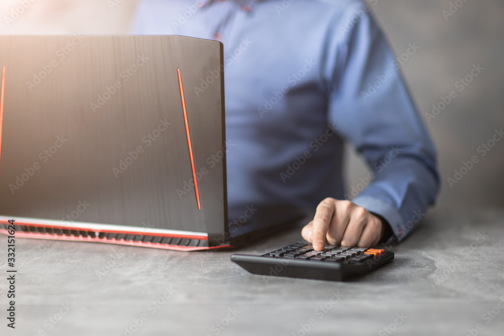 Bizmesmen przy laptopie liczączy na kalkulatorze. Bizmesmen przy laptopie liczączy na kalkulatorze.