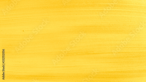 Light Gold or golden glossy acrylic paint textured background close up.