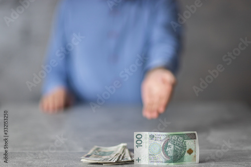 Oferta pożyczki, dłoń wskazująca na gotówke w nominałach 100zł