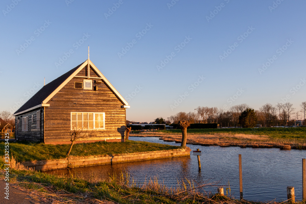 Wooden shed near waterfront in Dutch polder landscape