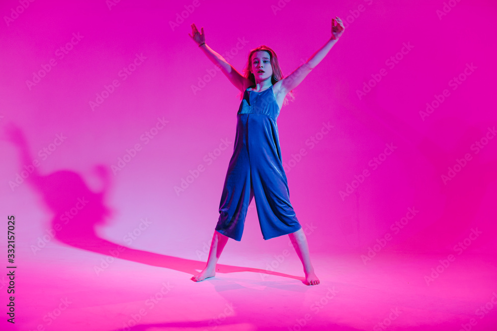 Young stylish girl dancing in the Studio on a colored neon background. Music dj poster design. Young stylish girl dancing in the Studio on a colored neon background. Music dj poster design.