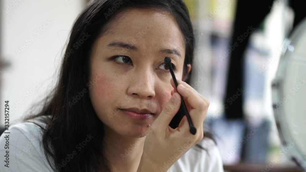 Beautiful middle age Asian woman do eyebrows make up brush foundation slow motion Beautiful middle age Asian woman do eyebrows make up brush foundation slow motion