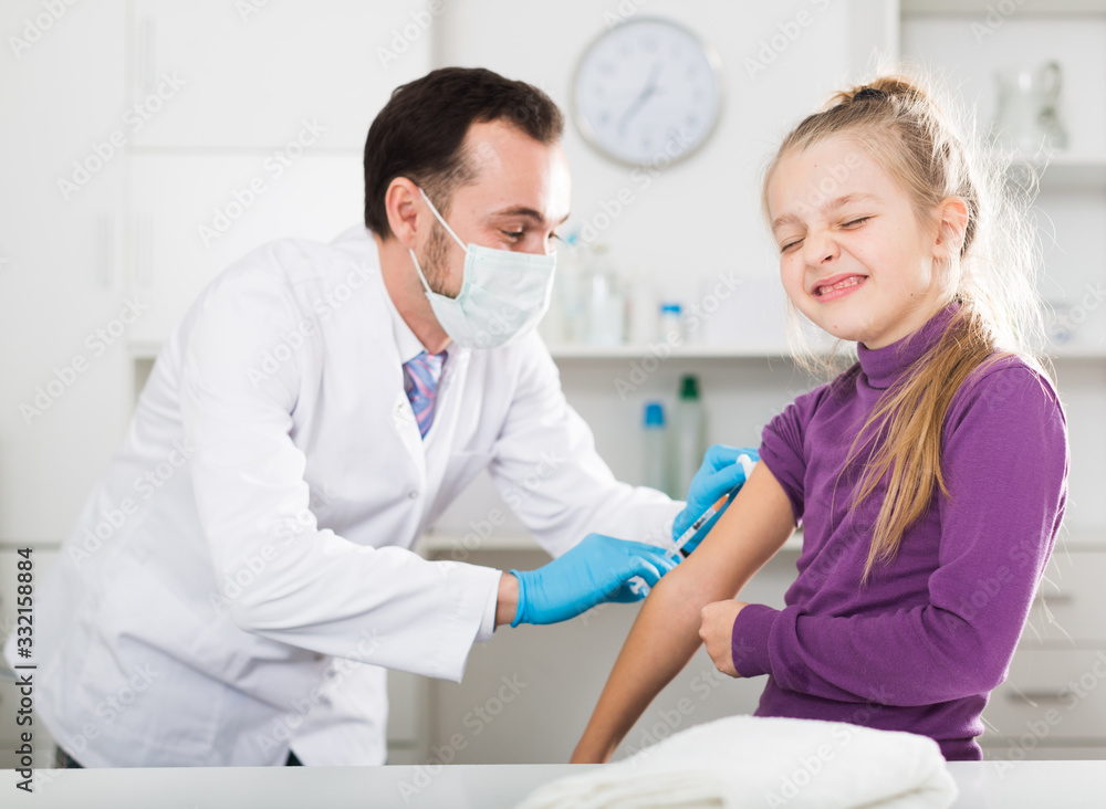 Fototapeta premium Male doctor injecting little patient