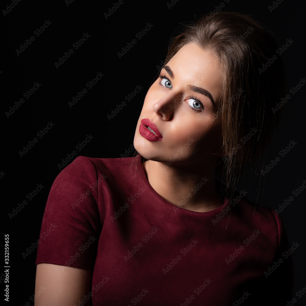 Portrait of attractive young woman over black background. Amazing girl with perfect makeup wearing elegant deep red dress. Beauty and fashion Portrait of attractive young woman over black background. Amazing girl with perfect makeup wearing elegant deep red dress. Beauty and fashion