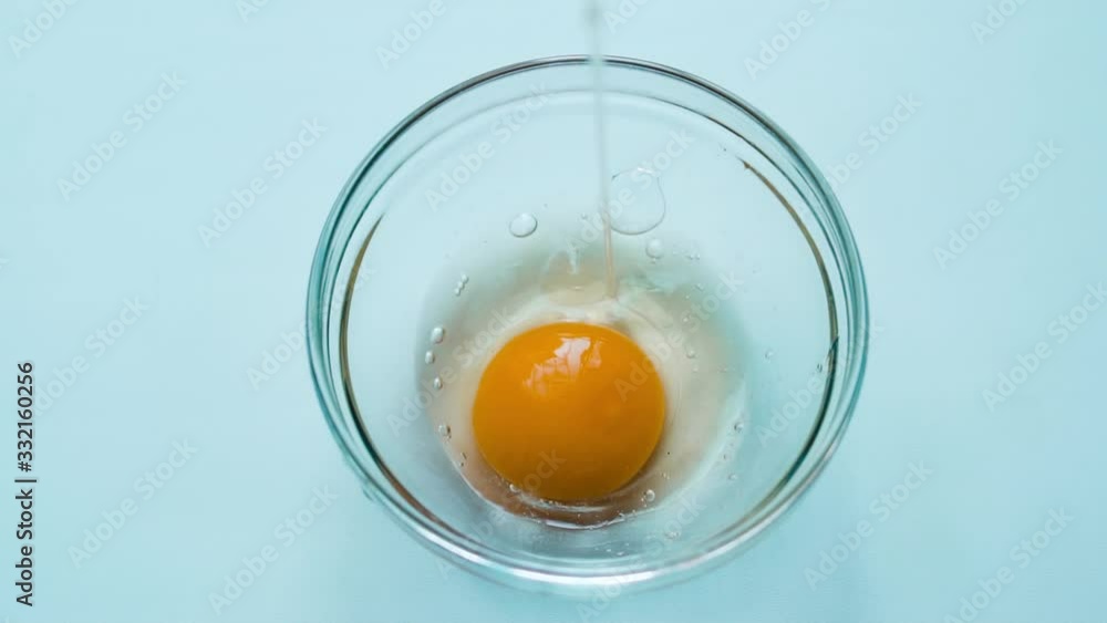 Slow motion shot cracking an egg in half into bowl in slow motion Slow motion shot cracking an egg in half into bowl in slow motion