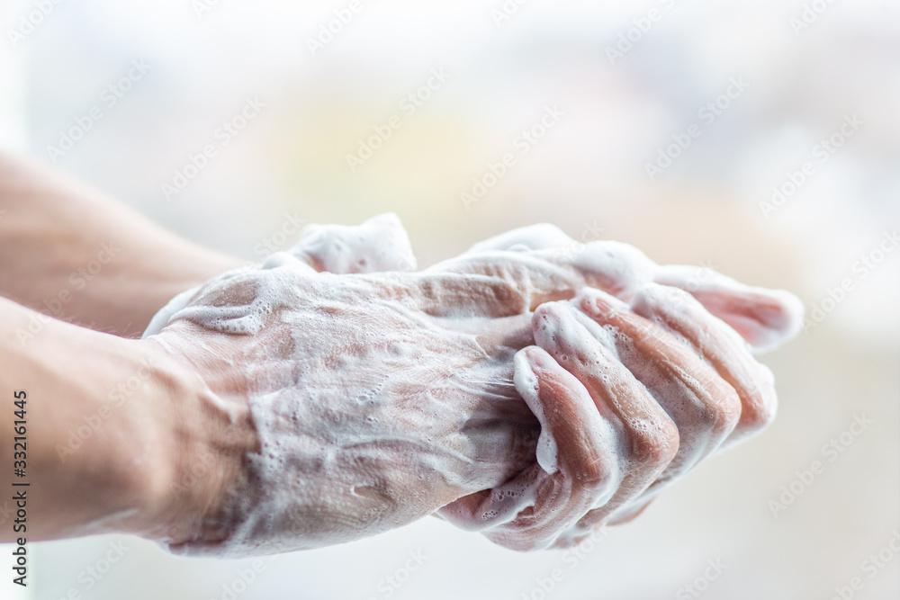 A man washes his hands with soap. Man's hands in foam with bubbles