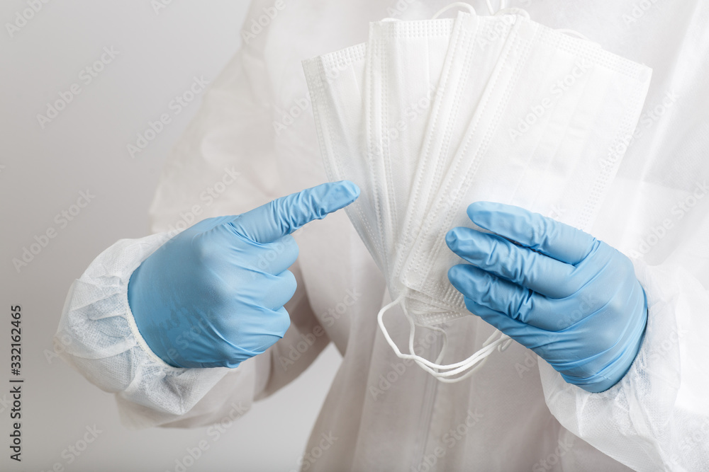 Doctor's hand with some medical face mask for protection against infection