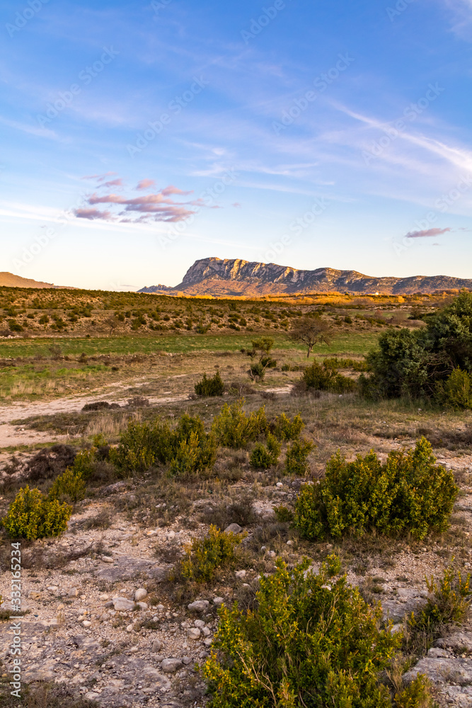 Face nord du Pic Saint-Loup, illuminée par le soleil couchant, dans un paysage quasi désertique de garrigue (Occitanie, France) Face nord du Pic Saint-Loup, illuminée par le soleil couchant, dans un paysage quasi désertique de garrigue (Occitanie, France)