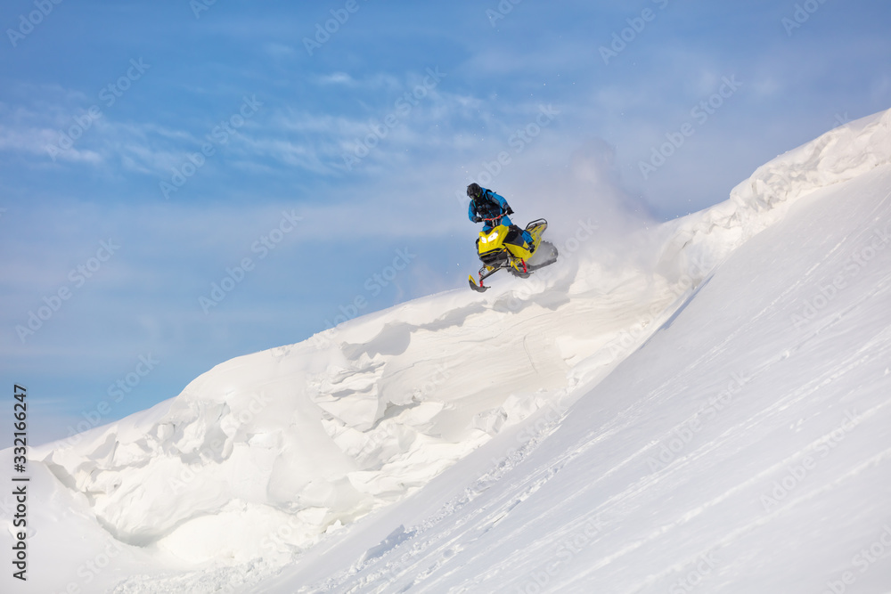 testing of a new model of mountain snowmobile, prototype 2021. jump on a mountain snowmobile from a high ledge with the descent of a large avalanche. snowmobilers sports riding. Winter extreme