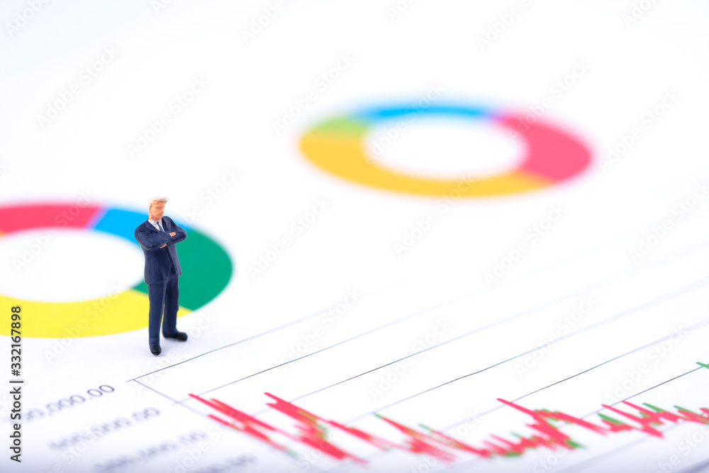 Miniature people:Businessman standing and see the the stock trend with copy space. Financial crisis. Data analysis. Stock market volatility risk. Information for investment. Financial concept Miniature people:Businessman standing and see the the stock trend with copy space. Financial crisis. Data analysis. Stock market volatility risk. Information for investment. Financial concept