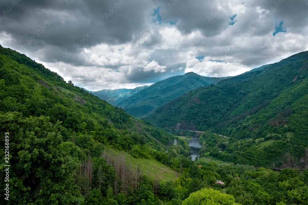 Amazing Aerial Landscape of Green Mountains and Hills with River in the middle and Dramatic Sky with Clouds. Amazing Aerial Landscape of Green Mountains and Hills with River in the middle and Dramatic Sky with Clouds.