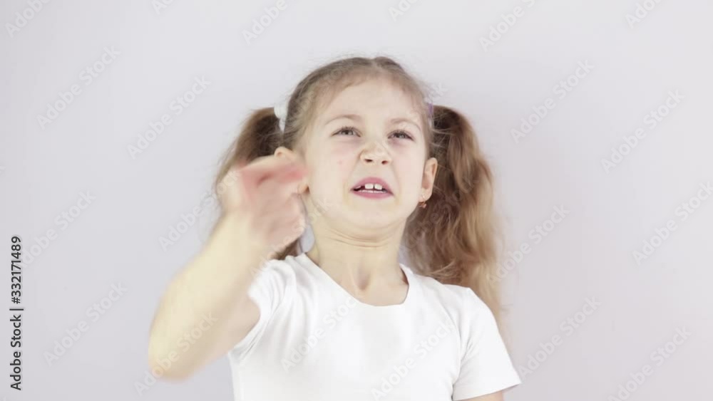 little girl is displeased and shakes her finger, making a threatening gesture in the Studio little girl is displeased and shakes her finger, making a threatening gesture in the Studio