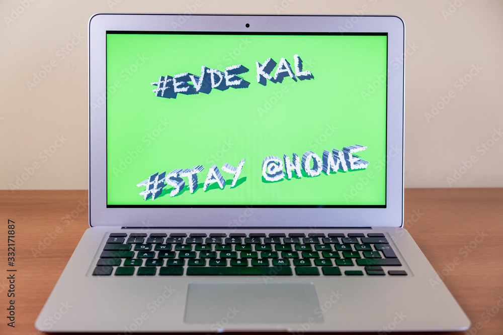 Writing attention message on notebook geenscreen reminder stay home (Turkish mean Writing attention message on notebook geenscreen reminder stay home (Turkish mean