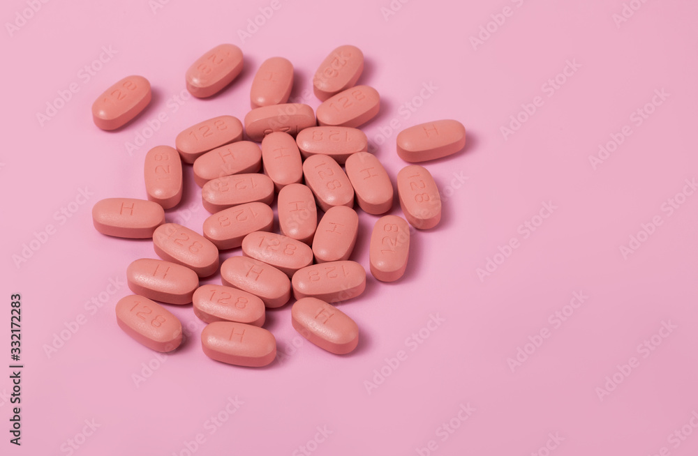 HIV/AIDS therapy pills on pink background. HIV/AIDS therapy pills on pink background.