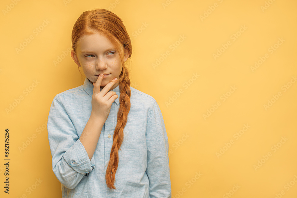 portrait of thoughtful caucasian red haired girl isolated over yellow background. adorable sly child girl conceived something, think and look side. emotions, people, natural beauty concept portrait of thoughtful caucasian red haired girl isolated over yellow background. adorable sly child girl conceived something, think and look side. emotions, people, natural beauty concept