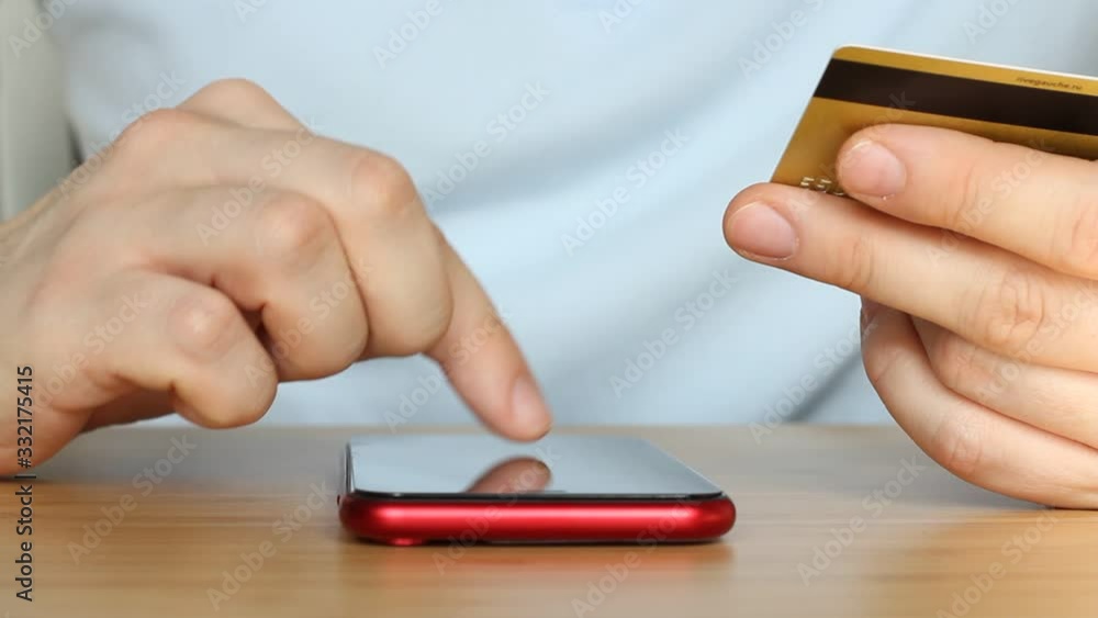 Man shopping online with credit card. Online banking with smart phone. Man enters the bank card number. Close up hands. Lifestyle technology and e-commers concept Man shopping online with credit card. Online banking with smart phone. Man enters the bank card number. Close up hands. Lifestyle technology and e-commers concept