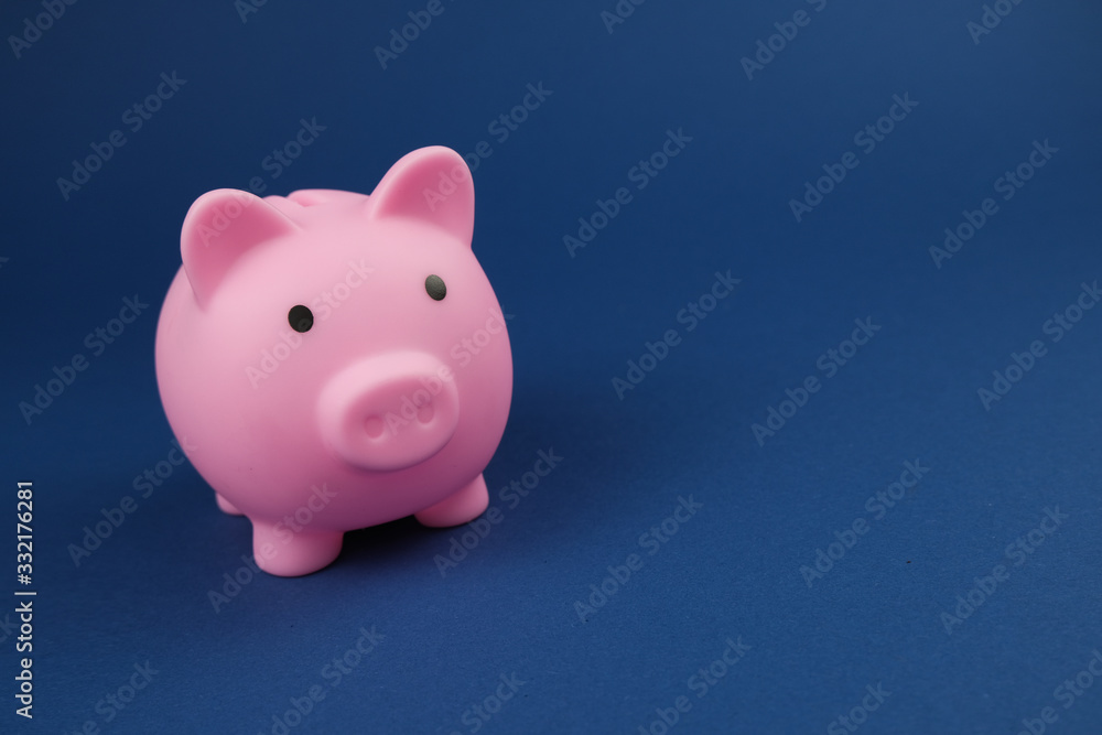 Pink piggy bank on the royal blue. background.Concept of saving money, investment, banking or business services