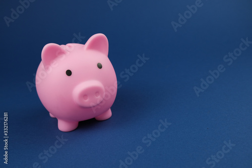 Pink piggy bank on the royal blue. background.Concept of saving money  investment  banking or business services