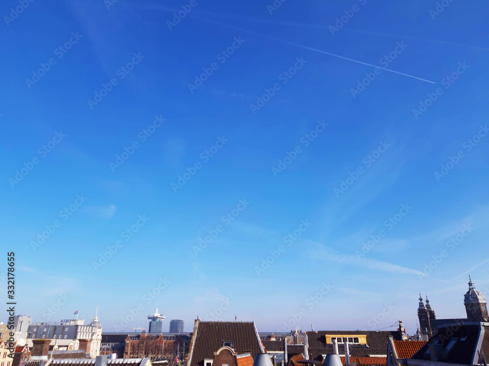 the roofs of houses in the center of Amsterdam under a clear sky