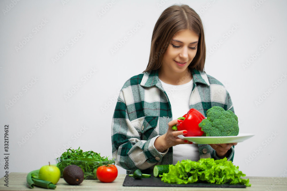 Concept of diet and healthy eating woman with vegetables on white wall background Concept of diet and healthy eating woman with vegetables on white wall background