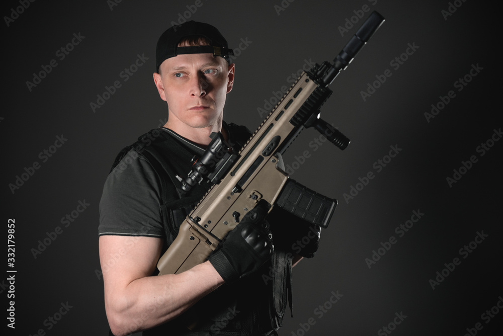 Concept of special agent man with an airsoft rifle on dark background. Concept of special agent man with an airsoft rifle on dark background.