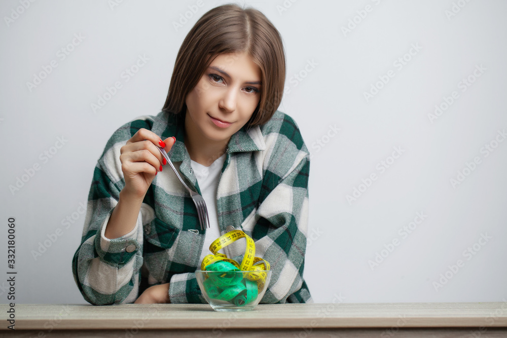 Concept of growing thin woman with plate full of tape measure Concept of growing thin woman with plate full of tape measure