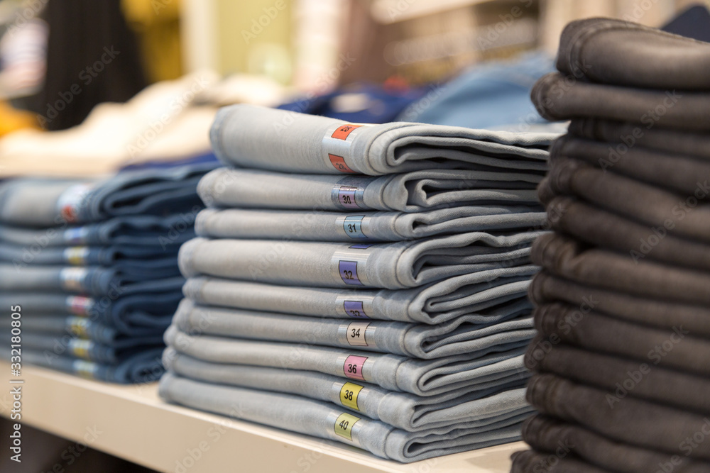 Male and female things in the store. Unfolded and hung goods on shelves in the clothing supermarket Male and female things in the store. Unfolded and hung goods on shelves in the clothing supermarket