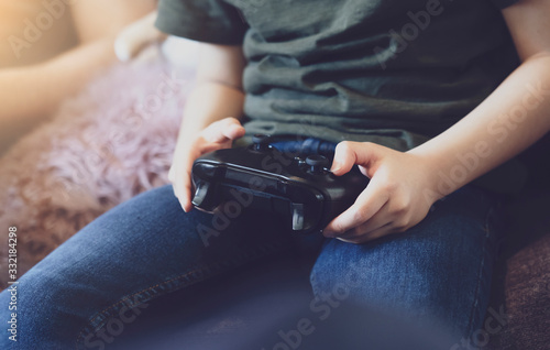 Hands Holding video game. Child playing video game online at home while school off  Quarantine and Social distancing or self  isolation lock down concept.