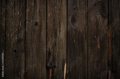 The texture of the Wooden wall a dark brown color with vertical boards in rustic style