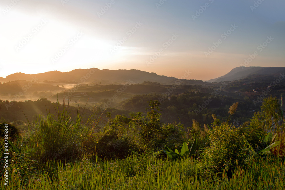 Obraz premium golden light fron sunrise on foggy mountain