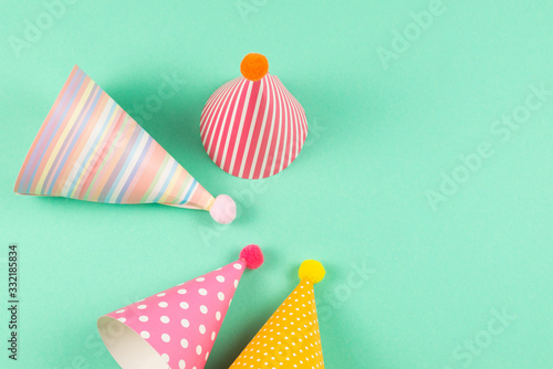 Colorful birthday caps on mint background.