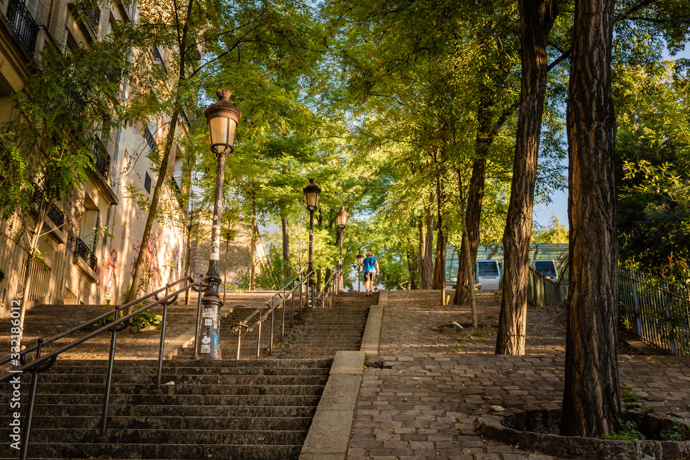 The famous steps of Montmartre, shaded by trees in the early morning sunlight, Paris, France