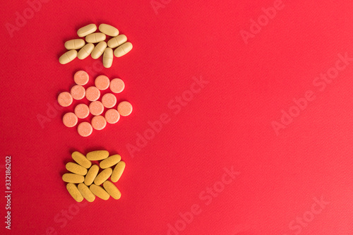 Healthy concept with Pharmaceutical medicine yellow pills, tablets and capsules on red background. Medicine creative concepts. medical pattern, top view, flat lay. Copy space