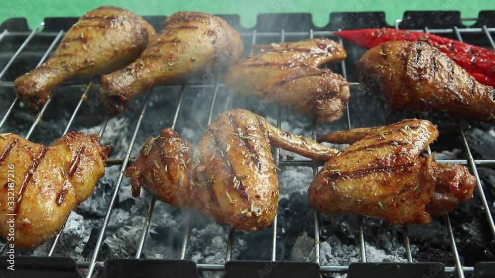 Grilled chicken wings on the barbecue griller. With tongs turn over meat poultry. cooking process Grilled chicken wings on the barbecue griller. With tongs turn over meat poultry. cooking process