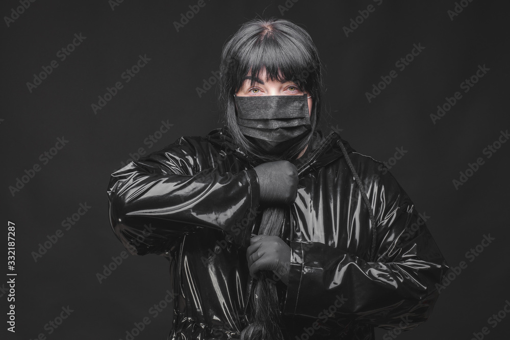 Female wearing protection face mask against coronavirus. Banner panorama woman preventive gear. Girl wearing gloves and latex coat protecting against covid. Black background and black mask
