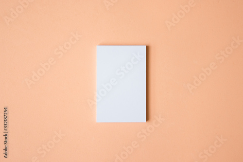 Mockup de tarjeta de visita blanca vertical sobre fondo color salmón