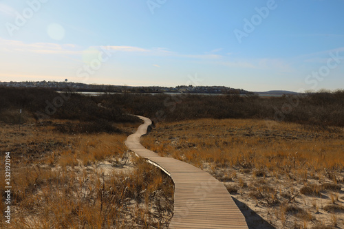 Fototapeta Naklejka Na Ścianę i Meble -  Plum Island, Ma November 2019 Wooden boardwalk winding through the sand dunes on a fall day