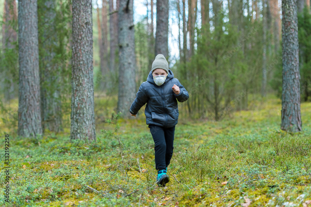 Little boy with a mask run in the forest. Corona virus quarantine