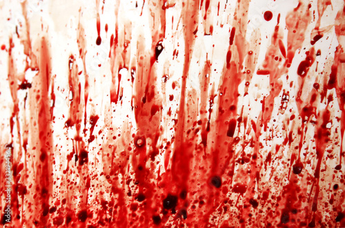 Splashes and smears of real clotted drop blood on a white surface. photo