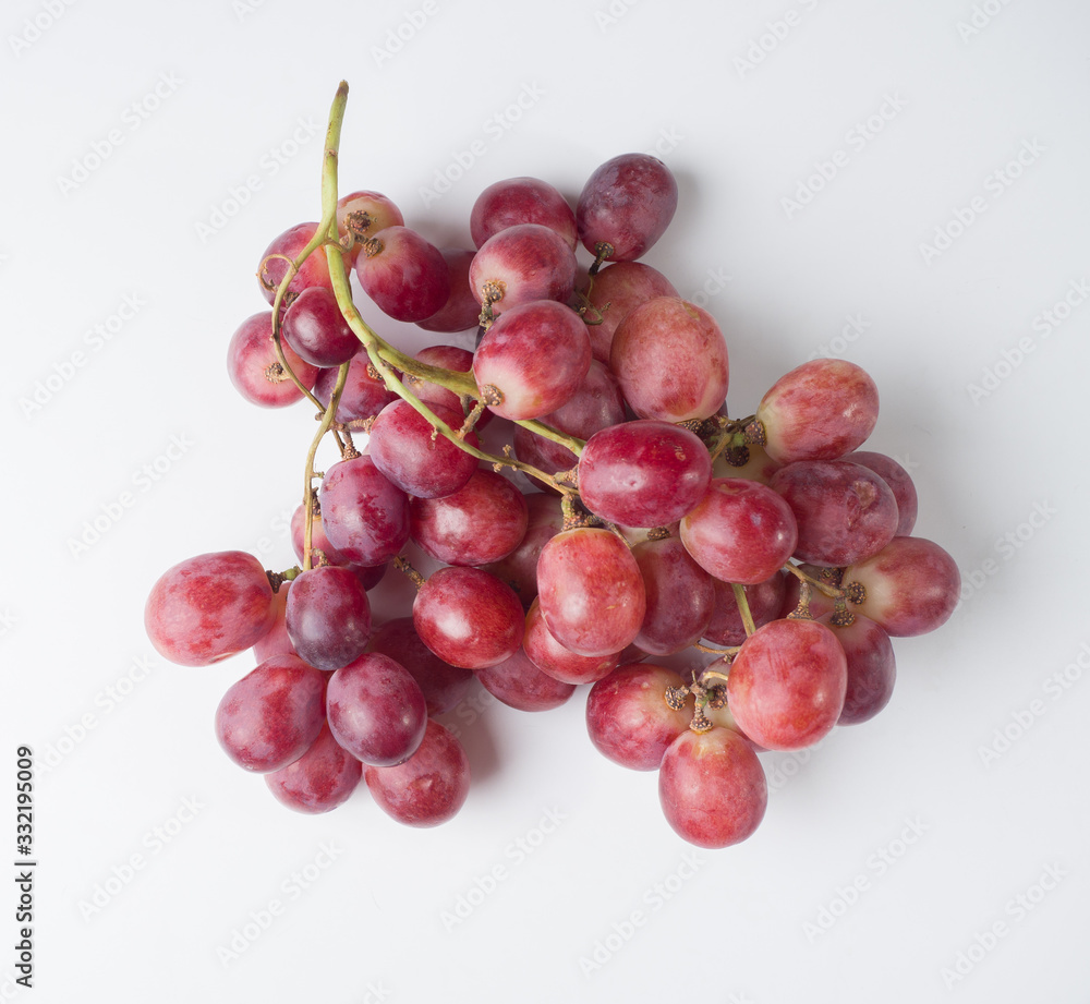Fototapeta premium A bunch of pink large grapes on a white background. Studio photography